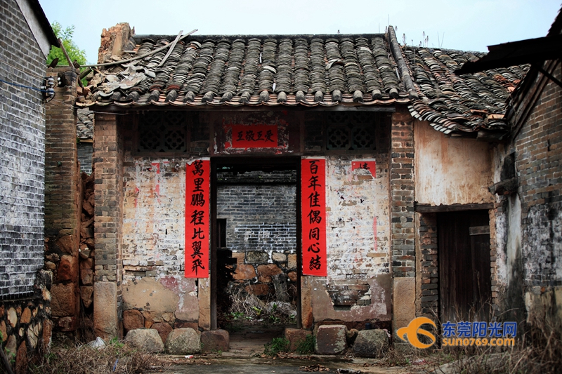 鲜红的对联,给老房子添了热闹屋门口的旧石磨老房探新枝黄砖房曾庇护